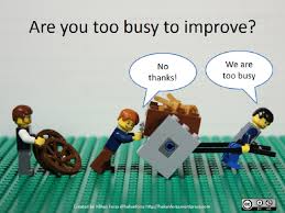 Lego characters carrying heaving load with another character offering to help with wheels; emphasizing too busy to improve