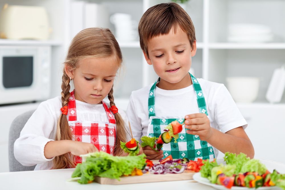 Young boy and girl in child care program learning to make healthy snacks and meals