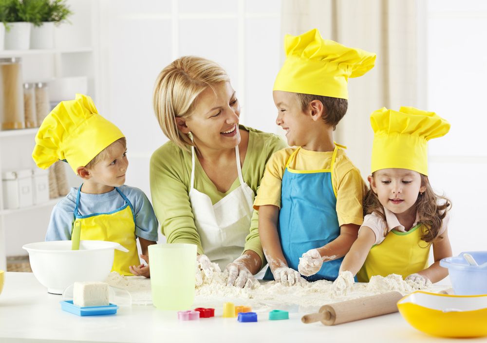 Preschool children in child care program with teacher learning to cook 