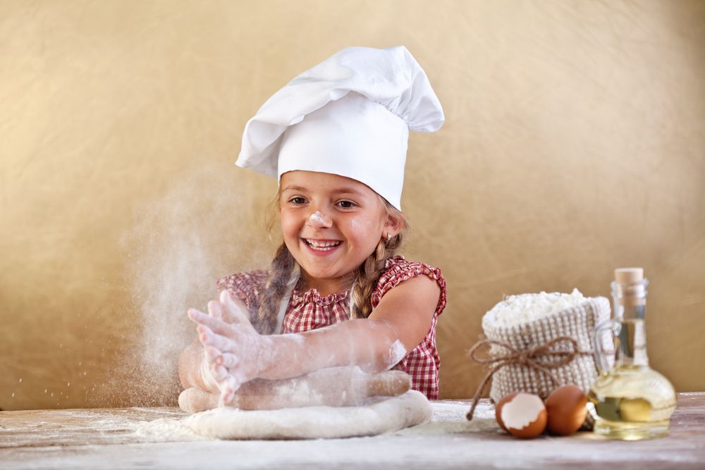 Young child learning to make pizza dough