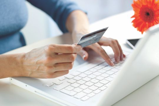 Woman working on her laptop paying for services with a secure credit card transaction